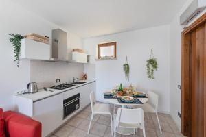 uma pequena cozinha com mesa e cadeiras num quarto em Mandorli 1-18 by Wonderful Italy em Desenzano del Garda