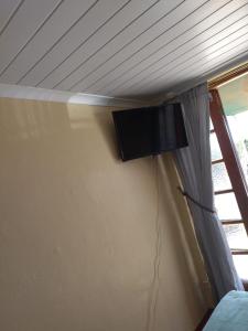 a tv hanging on a wall next to a window at Rebanien2 Overnight Accommodation Double and Single bed in De Aar