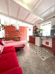 a living room with a red couch and a kitchen at Monte Carrascal Guesthouse in Salir