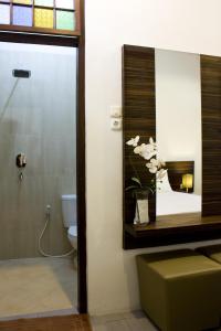 a bathroom with a toilet and a mirror at Grand Marto Hotel in Yogyakarta