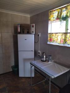 a small kitchen with a table and a refrigerator at Rebanien2 Overnight Accommodation Double and Single bed in De Aar