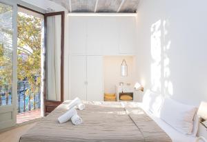 sypialnia z dużym łóżkiem i dużym oknem w obiekcie Canela Homes BARCELONA MARINA w Barcelonie