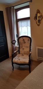 una silla sentada en una habitación con ventana en La Maison de Manon 
