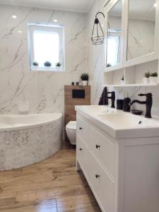 a white bathroom with a tub and a sink at ablotu - 2-8 person, parking,garden in Świnoujście