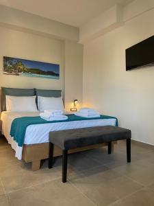 Michailidis Rooms في كينيتا: غرفة نوم مع سرير مع مقعد وتلفزيون
