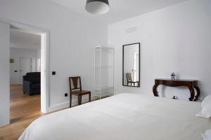 1 dormitorio con cama, espejo y silla en Albor Suites en Santa Brígida