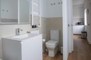 a white bathroom with a toilet and a sink at Albor Suites in Santa Brígida