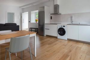 a kitchen and living room with a table and a washing machine at Albor Suites in Santa Brígida