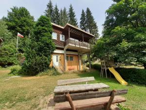 a house with a playground in front of it at Ferienhaus Bad Hundertpfund Typ A in Großbreitenbach
