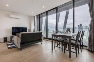 a dining room with a table and chairs and a large window at Modern 2 Beds Apartment with Amazing City View in Melbourne