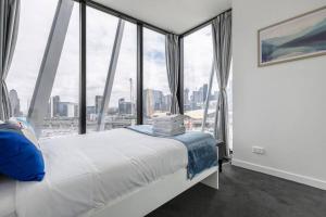 a bedroom with a bed and a large window at Modern 2 Beds Apartment with Amazing City View in Melbourne