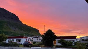 einen Sonnenuntergang über einer Stadt mit einem Berg in der Unterkunft Westfjords - Rooms in Bolungarvík