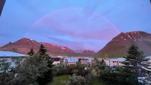 einen Blick auf eine Bergkette mit einem Regenbogen im Himmel in der Unterkunft Westfjords - Rooms in Bolungarvík