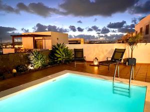 a swimming pool in front of a house at Villa Tabaiba Playa Blanca Lanzarote in Playa Blanca