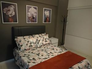 a bedroom with a bed and pictures on the wall at Lindo apto Recreio RJ, em frente ao Rio Centro in Rio de Janeiro