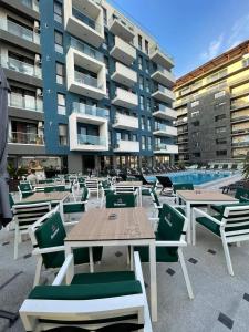 une terrasse avec des tables et des chaises devant un bâtiment dans l'établissement Studiou Andu Nord 10 by Alezzi, à Năvodari