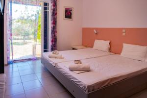 Posteľ alebo postele v izbe v ubytovaní Tsamadanis Hotel & Bungalows Friends Family