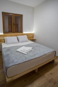a bed with two white towels on top of it at Monte Pino Lux Apartments in Žabljak