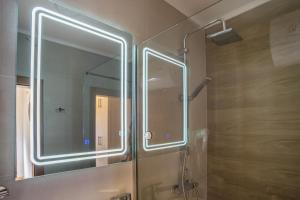 a bathroom with a shower with a large mirror at Monte Pino Lux Apartments in Žabljak +69 photos