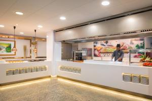 a food court with a chef behind the counter at htop Royal Star SPA - Fun in Lloret de Mar