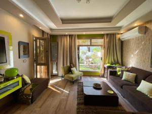 a living room with a couch and a table at Luxury Mamoura Alexandria Apartment شقة فاخرة بجنينة خاصة بالمعمورة الشاطئ بالإسكندرية in Alexandria