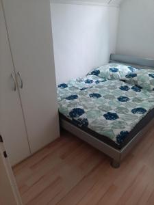 ein kleines Schlafzimmer mit einem Bett mit einer Decke darauf in der Unterkunft Hostel Airport in Oberglatt