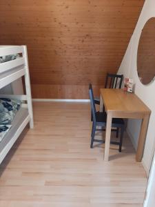 a room with a table and chairs and a bunk bed at Hostel Airport in Oberglatt