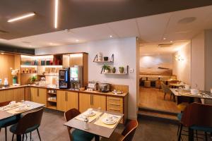 a restaurant with tables and chairs and a kitchen at Hotel Des Remparts Lyon Perrache in Lyon