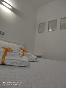 eine Reihe von Handtüchern mit orangefarbenen Bogen auf einem Bett in der Unterkunft Perla Saracena in Lucera