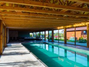 an indoor swimming pool with a wooden ceiling at Ostoja Maltańska in Jezierzany