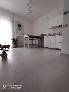a large white kitchen with a table in a room at Perla Saracena in Lucera