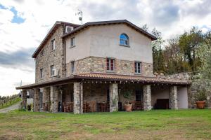 an old stone house on a grass field at Agriturismo I Giunchi in Mochignano