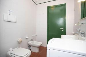 a bathroom with a toilet and a green door at Sant'Anna Vicolo Aranci 5 in Portoferraio +12 photos