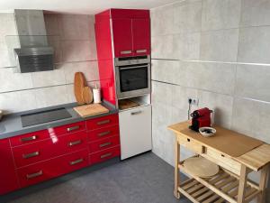 a small kitchen with red cabinets and a white refrigerator at Casa Tajo in Tarifa +14 photos