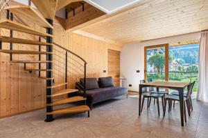 a wooden house with a spiral staircase in a living room at Ciasa Fatati in Pinzolo