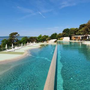 a swimming pool with blue water and a beach at Mobile Home Mar Vista Selce in Selce