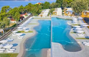 a view of a pool with lounge chairs and the ocean at Mobile Home Mar Vista Selce in Selce