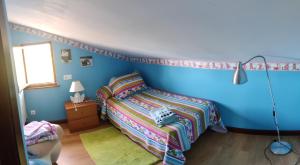 um quarto azul com uma cama e um candeeiro em Casa Villa Ruiz em Po
