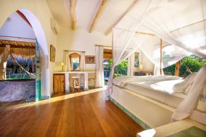 a bedroom with a bed with a canopy at Mu Bungalows in Uluwatu
