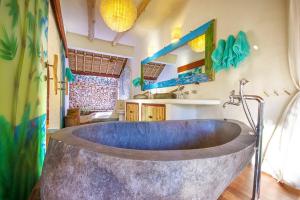 a bathroom with a large tub in a room at Mu Bungalows in Uluwatu