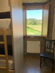 a room with a window and a bunk bed at Albergue Rectoral San Mamede da Pena EXCLUSIVE FOR PILGRIMS in Negreira