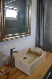 a stone sink in a bathroom with a mirror at Estúdio com espaço exterior, 5 minutos de Cascais. in Cascais