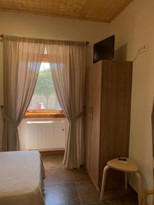 1 dormitorio con cama y ventana en Albergue Rectoral San Mamede da Pena EXCLUSIVE FOR PILGRIMS, en Negreira