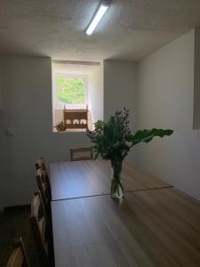 un jarrón de flores sentado en una mesa en una habitación en Albergue Rectoral San Mamede da Pena EXCLUSIVE FOR PILGRIMS, en Negreira