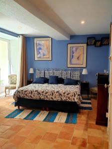 1 dormitorio con paredes azules y 1 cama con almohadas azules en Alcôve Marine, en Gruissan
