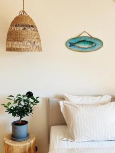 a potted plant on a table next to a bed at Pāvilostas Šīfermāja in Pāvilosta