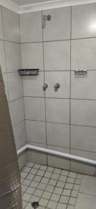a shower in a bathroom with white tile at Rebanien2 Overnight Accommodation Double and Single bed in De Aar