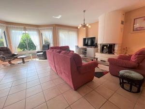 a living room with two red chairs and a fireplace at Maison familiale à Fouesnant avec jardin clos, proche plages et centre-ville - FR-1-481-103 in Fouesnant