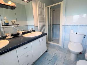 a bathroom with two sinks and a toilet and a shower at Maison familiale à Fouesnant avec jardin clos, proche plages et centre-ville - FR-1-481-103 in Fouesnant +16 photos