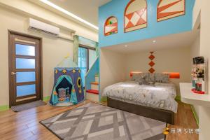 ein Kinderschlafzimmer mit einem Bett und einem Spielzelt in der Unterkunft 花蓮旋轉吧小人國親子民宿 in Hualien